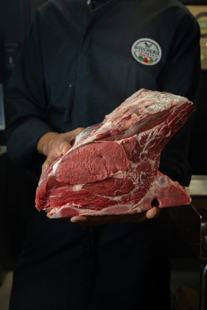 Boucher présentant une pièce de bœuf halal certifiée ACHAHADA